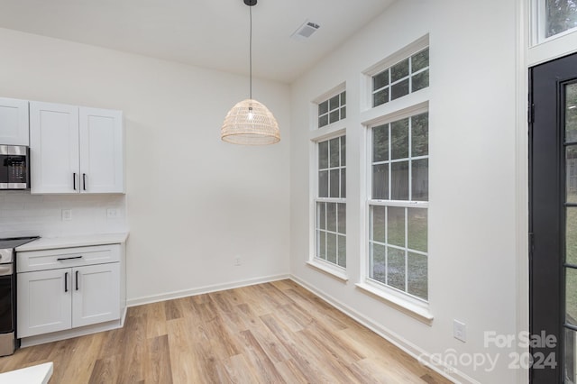 unfurnished dining area with light wood-type flooring