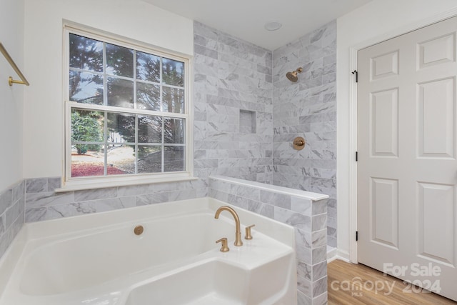 bathroom featuring hardwood / wood-style flooring and independent shower and bath