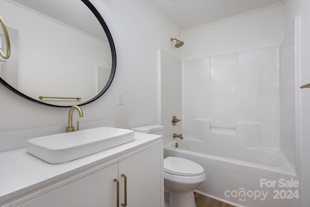 full bathroom with toilet, wood-type flooring, ornamental molding,  shower combination, and vanity