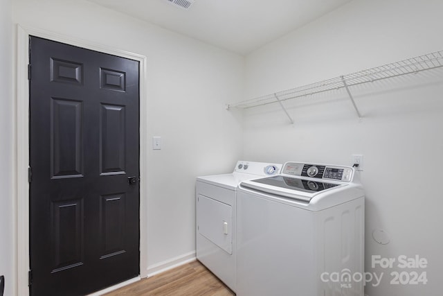 laundry room featuring washer and dryer and light wood-type flooring