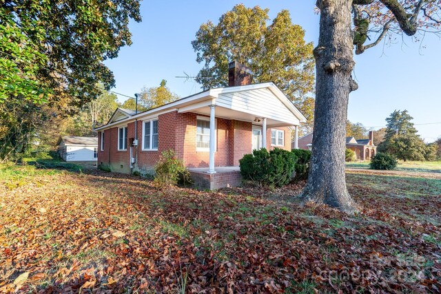 24947 Nc-24/27 Hwy, Albemarle, NC 28001 - view of front of house with brick siding, a chimney, and covered porch