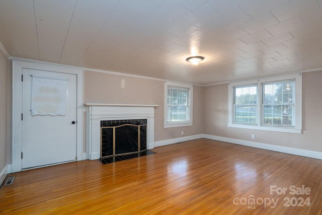 24947 Nc-24/27 Hwy, Albemarle, NC 28001 - unfurnished living room with a fireplace with flush hearth, crown molding, and light wood finished floors