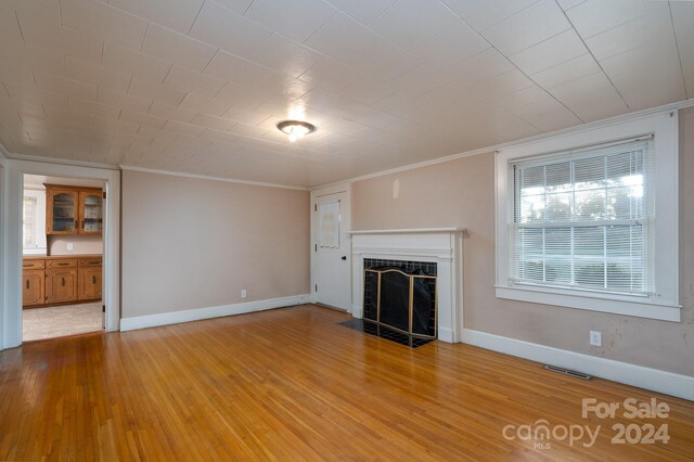 24947 Nc-24/27 Hwy, Albemarle, NC 28001 - unfurnished living room with ornamental molding, wood finished floors, and a fireplace with flush hearth
