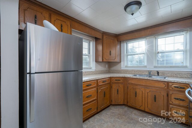 24947 Nc-24/27 Hwy, Albemarle, NC 28001 - kitchen with freestanding refrigerator, brown cabinetry, and light countertops
