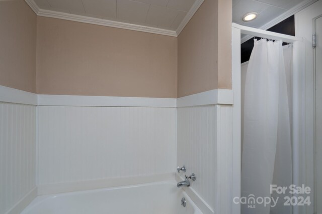 24947 Nc-24/27 Hwy, Albemarle, NC 28001 - bathroom featuring a bathtub, crown molding, a shower with shower curtain, and wainscoting