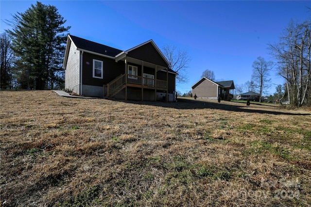 back of property with a porch and a yard