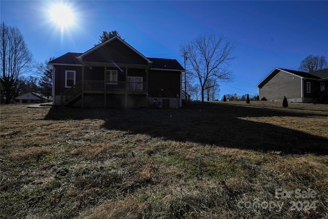 rear view of house with a lawn and covered porch