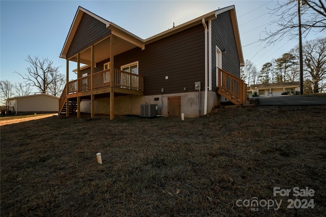 rear view of house with a wooden deck and central air condition unit