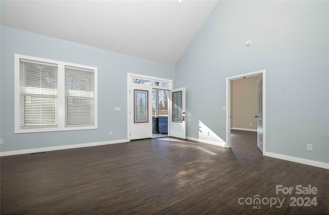 unfurnished living room featuring high vaulted ceiling and dark hardwood / wood-style floors