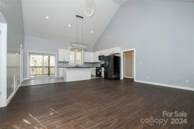 unfurnished living room featuring dark hardwood / wood-style flooring, high vaulted ceiling, a notable chandelier, and sink