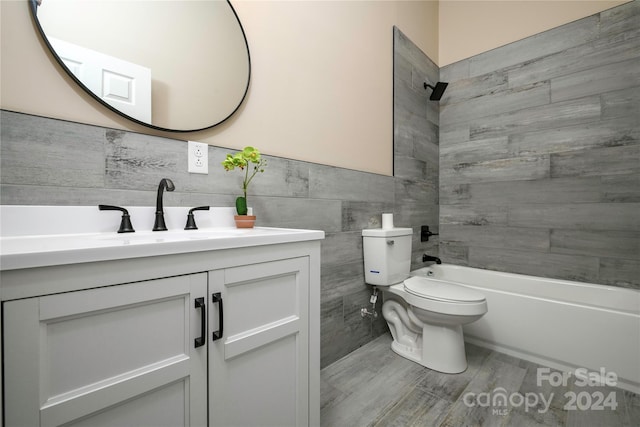 full bathroom featuring vanity, toilet, tile walls, and tiled shower / bath combo