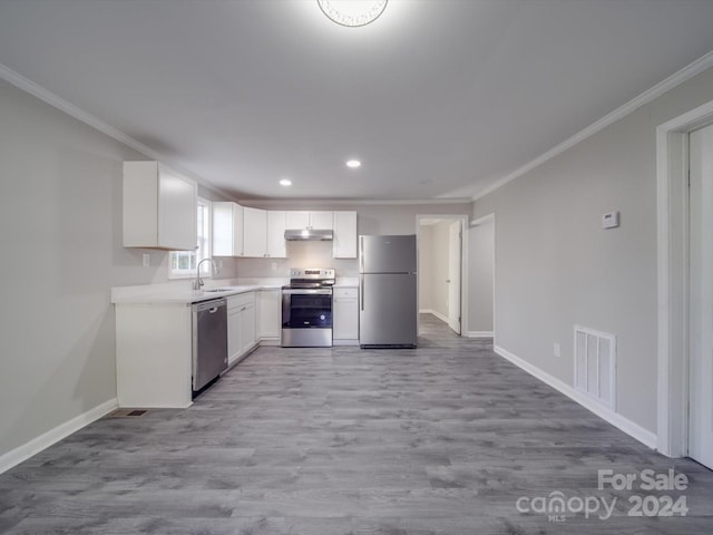 kitchen featuring light wood-type flooring, ornamental molding, stainless steel appliances, sink, and white cabinets