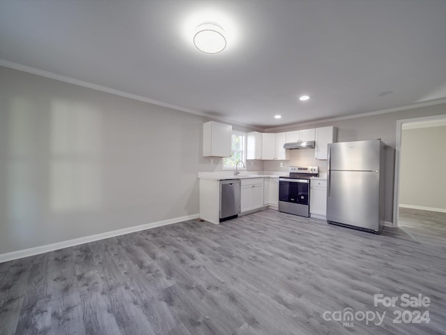 kitchen featuring white cabinets, crown molding, appliances with stainless steel finishes, and light hardwood / wood-style flooring