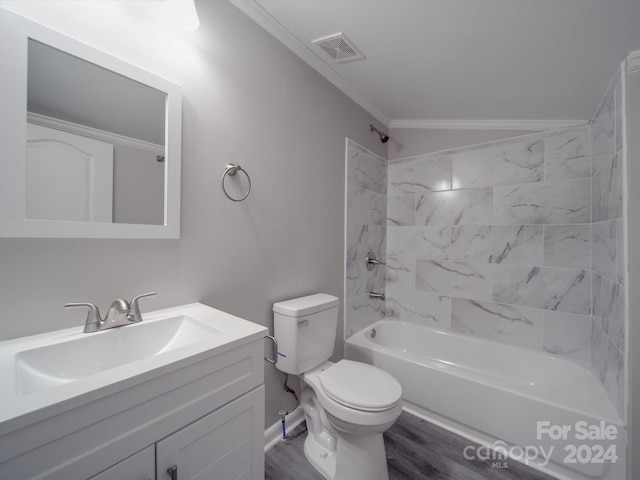 full bathroom featuring ornamental molding, vanity, wood-type flooring, toilet, and tiled shower / bath