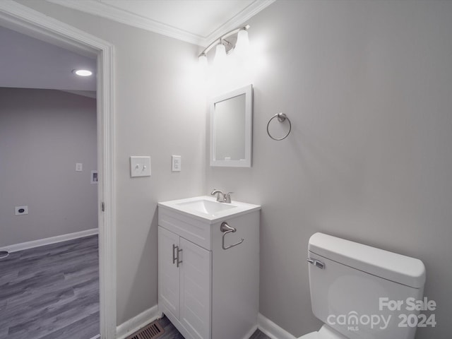 bathroom featuring hardwood / wood-style floors, vanity, toilet, and ornamental molding