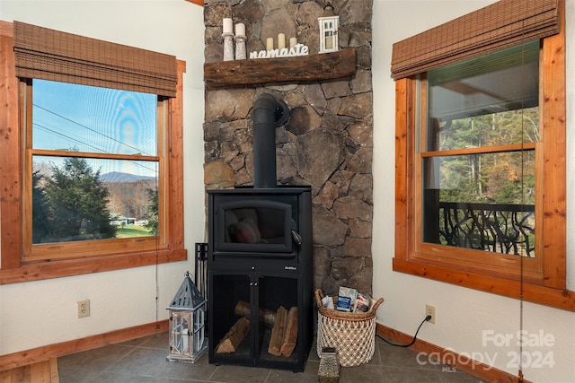 living room with a wood stove and dark tile patterned floors