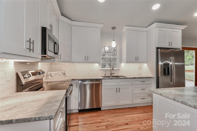 kitchen with stainless steel appliances, white cabinetry, and sink