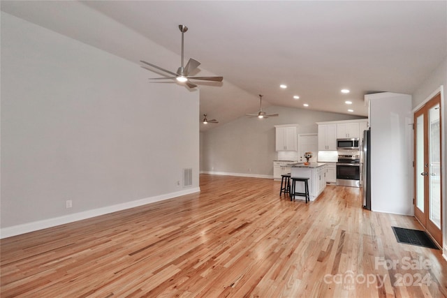 unfurnished living room with french doors, light hardwood / wood-style floors, vaulted ceiling, and ceiling fan