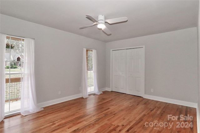 unfurnished bedroom with a closet, light hardwood / wood-style floors, and ceiling fan