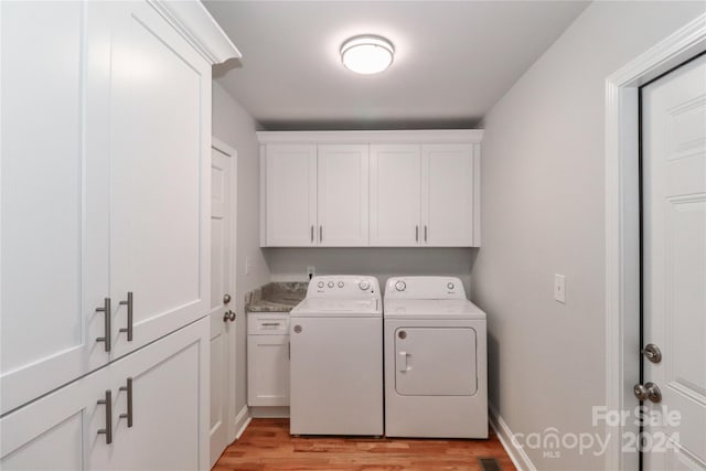 washroom with cabinets, separate washer and dryer, and light hardwood / wood-style flooring