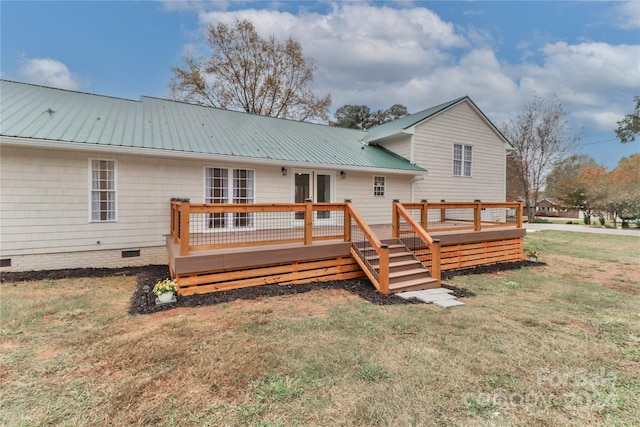 back of property featuring a lawn and a wooden deck