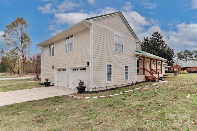 view of side of home with a lawn, covered porch, and a garage