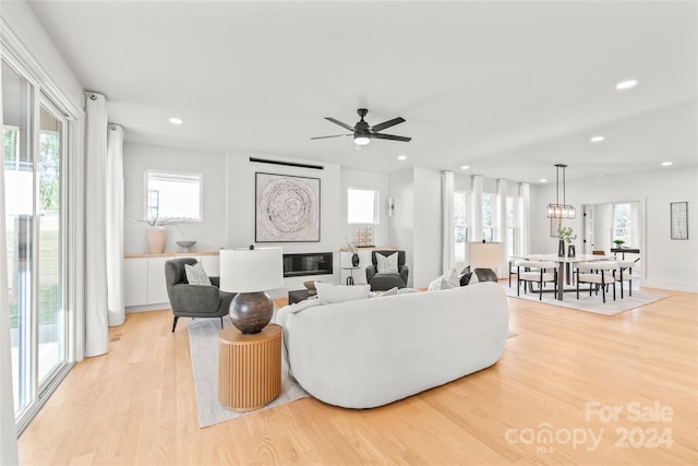 living room with light hardwood / wood-style flooring and ceiling fan