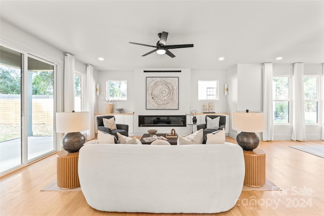 living room featuring light wood-type flooring, plenty of natural light, and ceiling fan