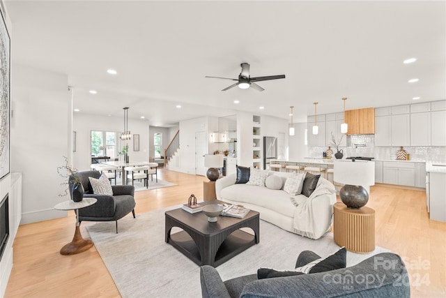 living room featuring ceiling fan and light hardwood / wood-style flooring