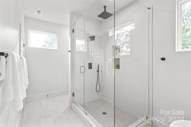 bathroom with an enclosed shower and a wealth of natural light