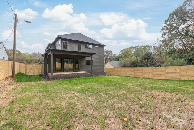 rear view of house with a patio area and a yard