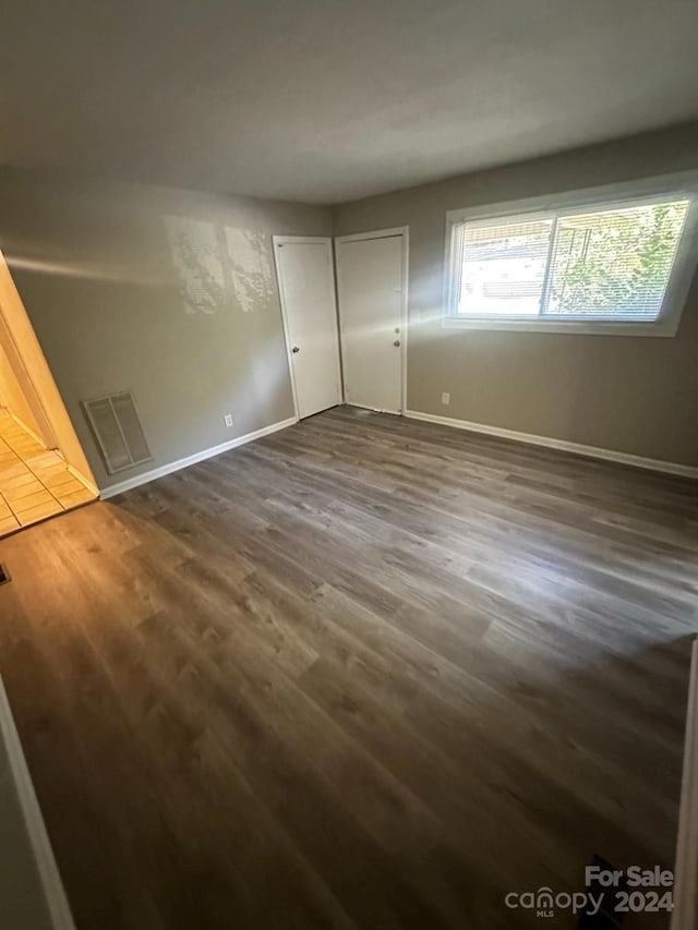 unfurnished bedroom with dark wood-type flooring