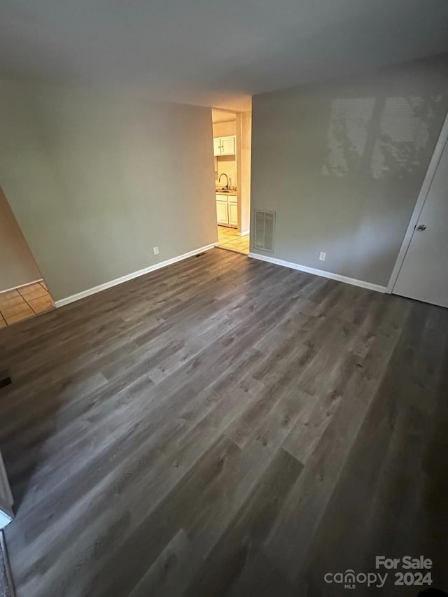 empty room with sink and dark hardwood / wood-style flooring