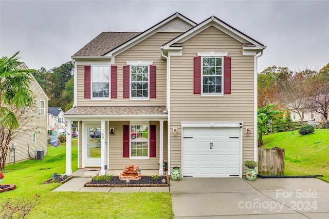 view of front of property with cooling unit, a garage, and a front lawn