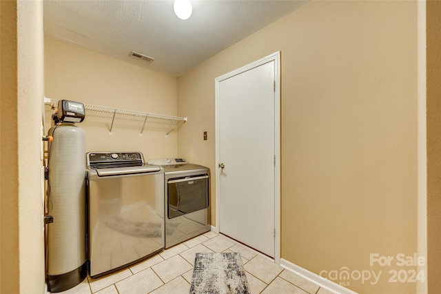 washroom featuring light tile patterned flooring, a textured ceiling, and independent washer and dryer