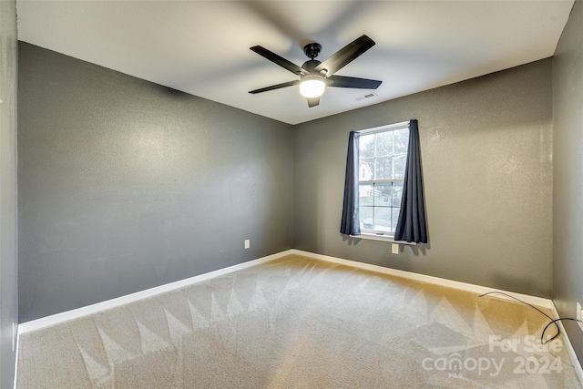 spare room with ceiling fan and carpet