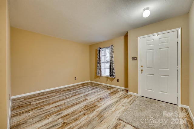 foyer with a textured ceiling and light wood-type flooring