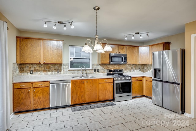 kitchen featuring sink, decorative light fixtures, appliances with stainless steel finishes, tasteful backsplash, and a notable chandelier