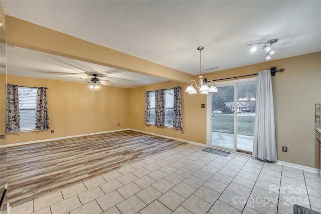 spare room featuring ceiling fan with notable chandelier and light hardwood / wood-style floors