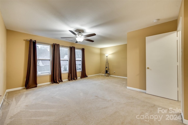 carpeted spare room with ceiling fan