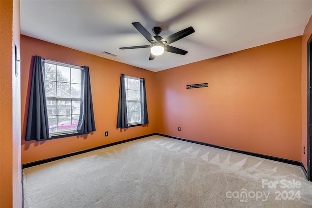 unfurnished room featuring ceiling fan and light carpet