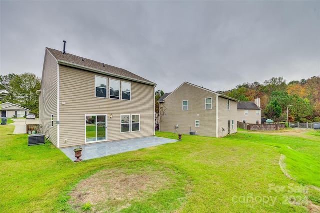 rear view of house featuring a patio, central air condition unit, and a lawn