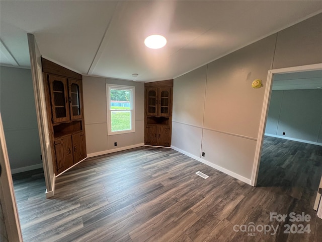 unfurnished living room featuring dark hardwood / wood-style flooring and vaulted ceiling