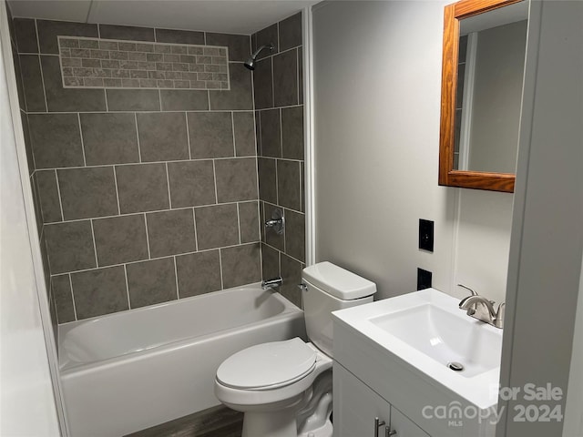 full bathroom with vanity, toilet, wood-type flooring, and tiled shower / bath combo