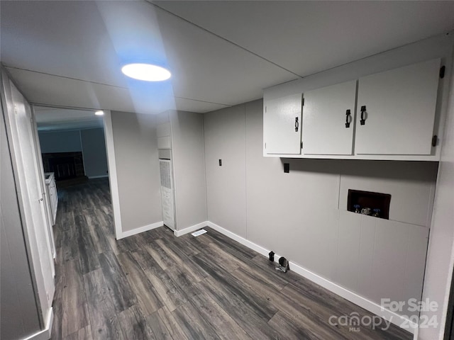 laundry area featuring cabinets, washer hookup, dark hardwood / wood-style flooring, and a brick fireplace