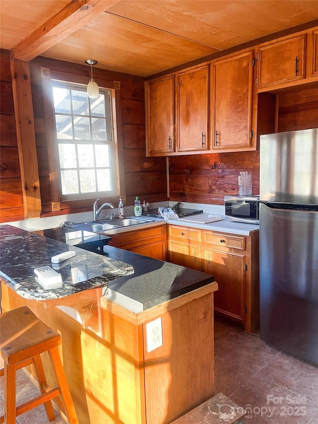 kitchen featuring sink, hanging light fixtures, wooden ceiling, appliances with stainless steel finishes, and kitchen peninsula