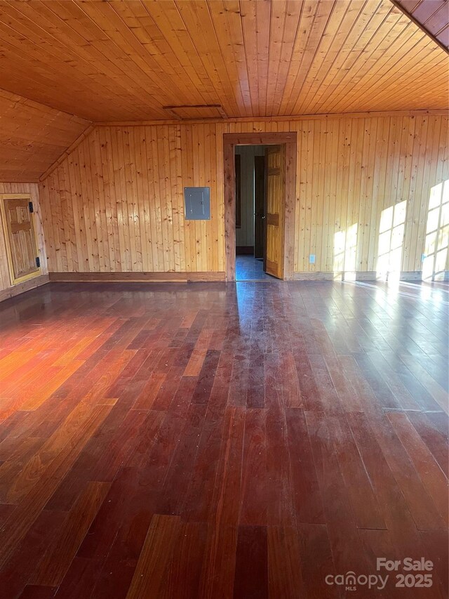 interior space featuring wood walls, lofted ceiling, electric panel, dark wood-type flooring, and wooden ceiling