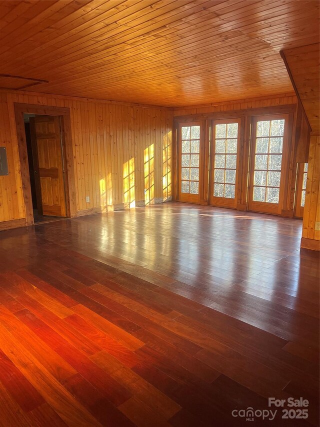 spare room featuring wood-type flooring, wooden walls, and wood ceiling