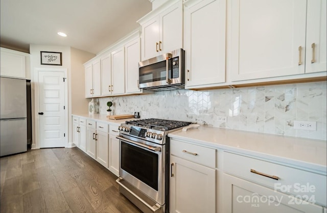 kitchen featuring white cabinetry, appliances with stainless steel finishes, decorative backsplash, and dark wood-type flooring