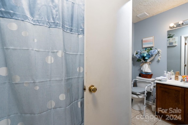 bathroom with vanity, walk in shower, toilet, and tile patterned floors